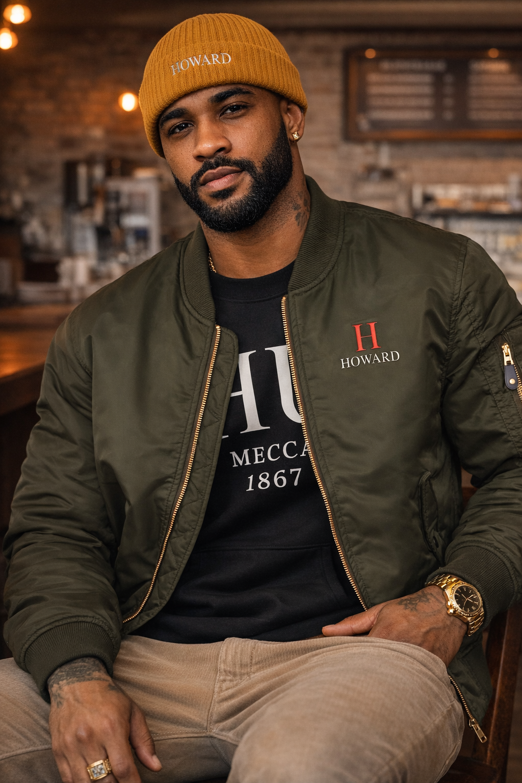 Man wearing a green jacket with 'Howard' logo, black t-shirt, and yellow beanie in a casual setting.